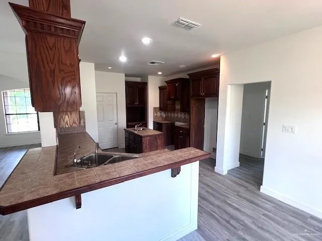 a view of kitchen with refrigerator stove and wooden floor