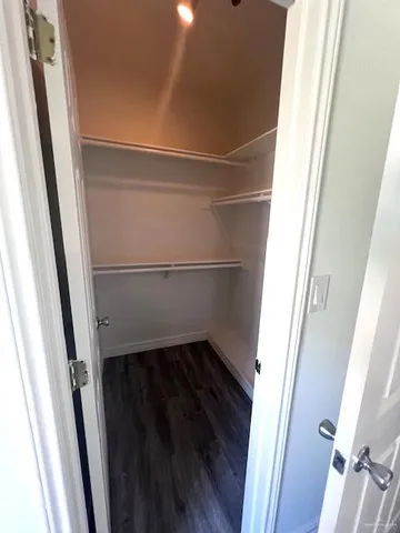 a view of walk in closet with wooden floor