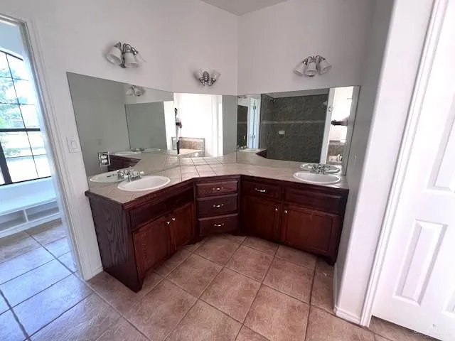 a room with a granite countertop sink and a mirror