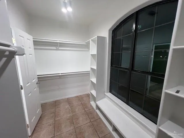 a bathroom with a glass door shower and closet