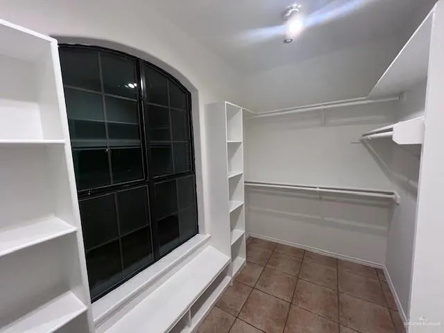 a view of walk in closet with empty racks