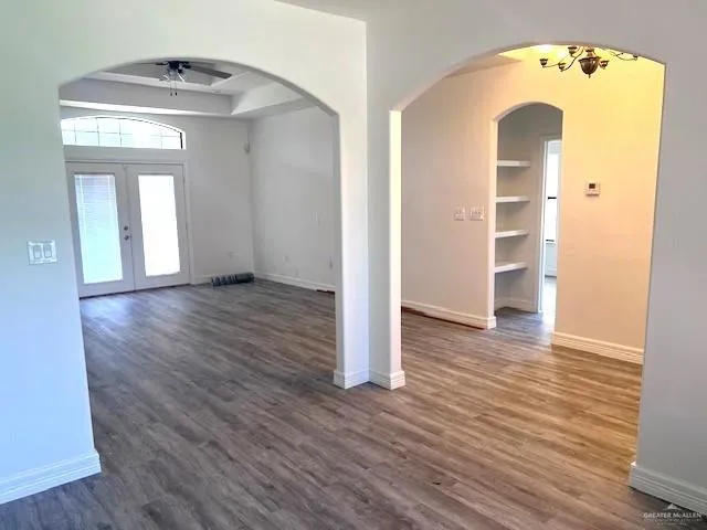 an empty room with wooden floor and a mirror