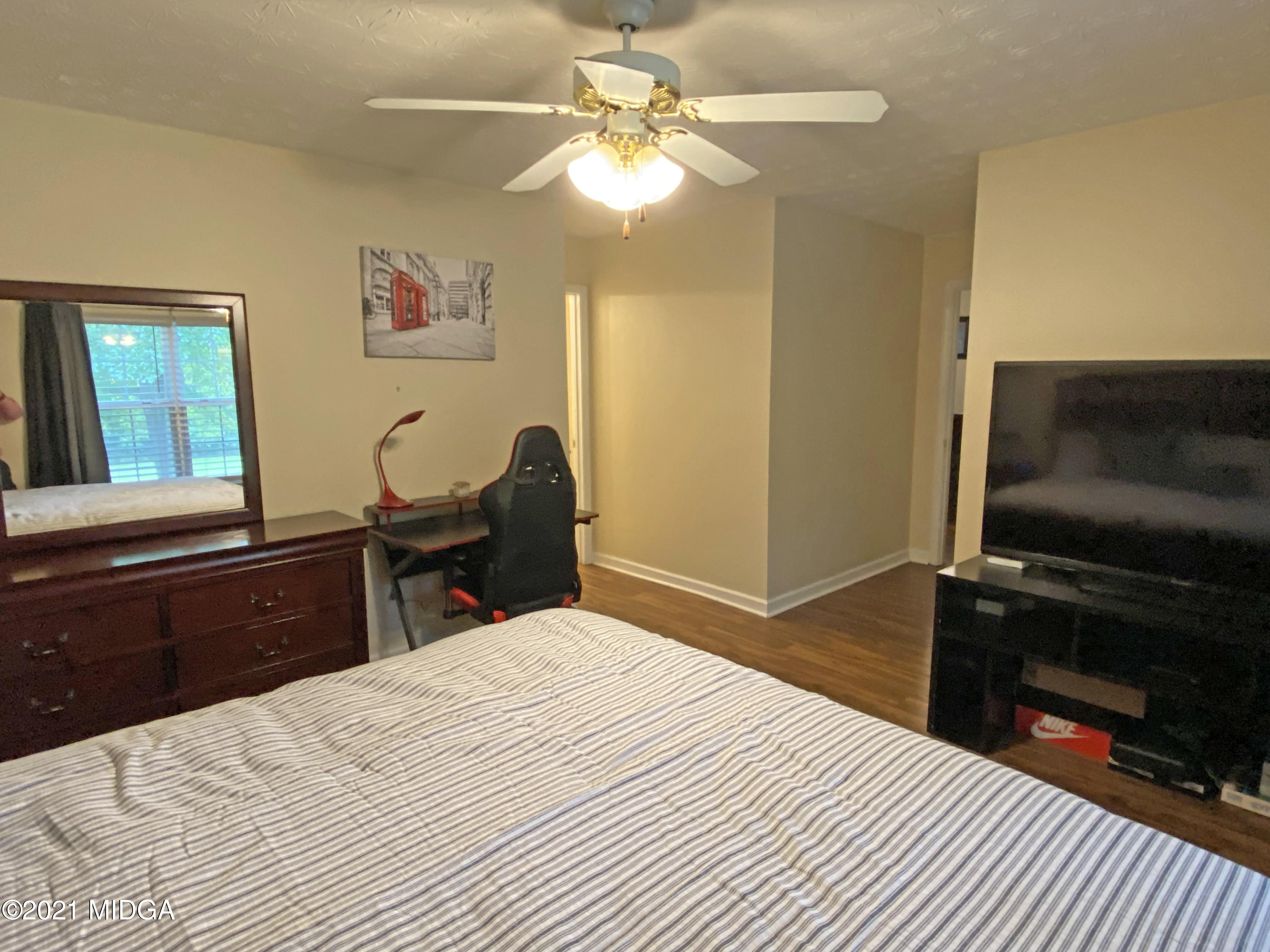 167 Apple Valley Road Macon, GA 31217 - Photo 12 of 25 a bedroom with a bed and a chandelier with a flat tv screen
