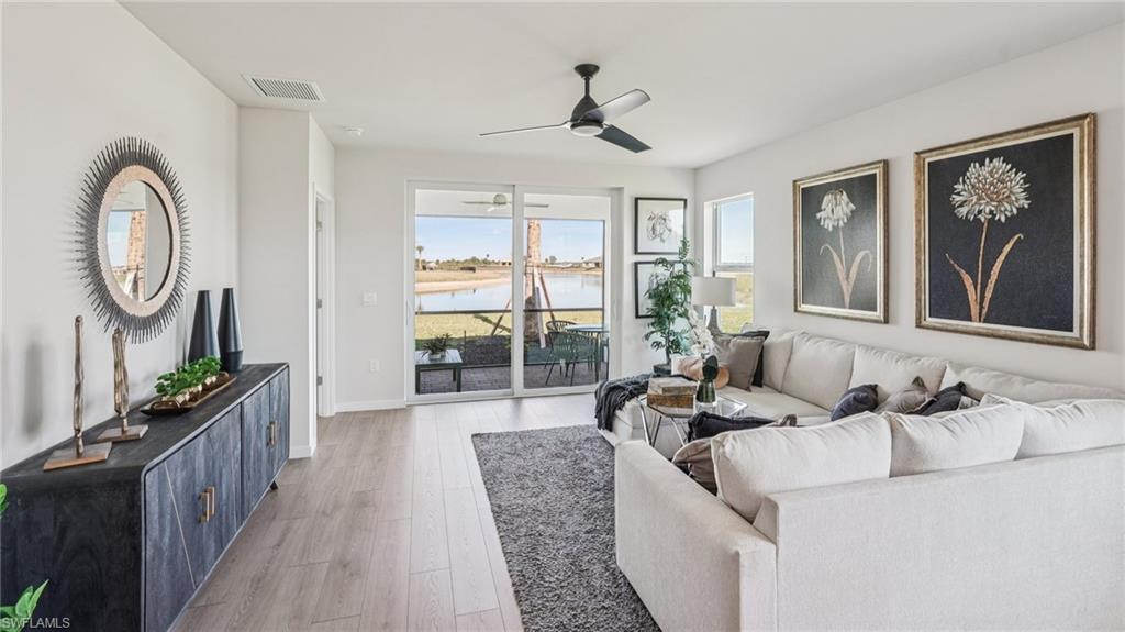 17584 Shade Tree Loop Punta Gorda, FL 33982 - Photo 4 of 35 Living space featuring wood-finish flooring, a contemporary ceiling fan, and large sliding glass doors opening to a covered patio