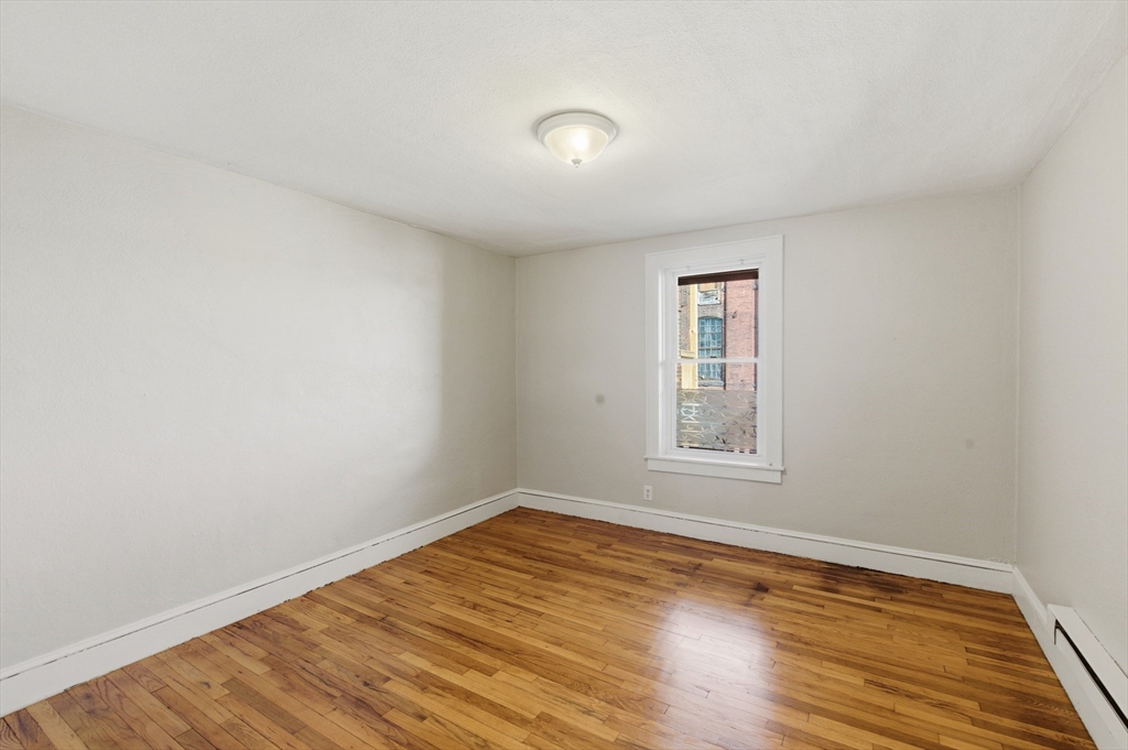 293 Clemente Street, Unit 3R Holyoke, MA 01040 - Photo 10 of 14 a view of empty room with wooden floor and fan