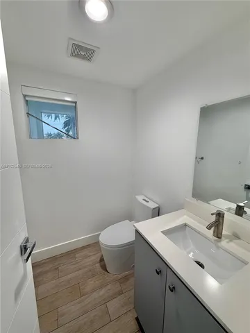 a bathroom with a sink mirror and toilet