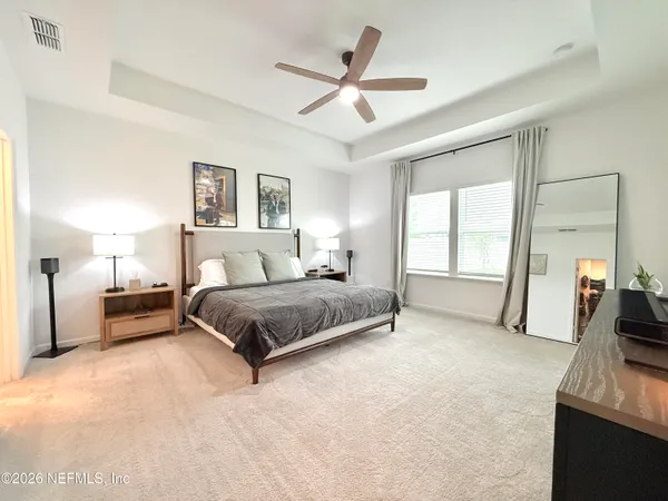 a spacious bedroom with a large bed and a chandelier
