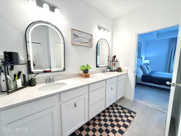 a spacious bathroom with a double vanity sink and a mirror