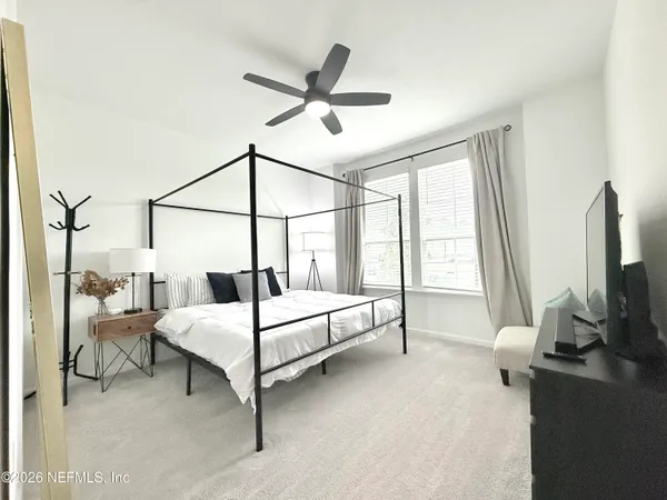 a bedroom with a bed and large windows