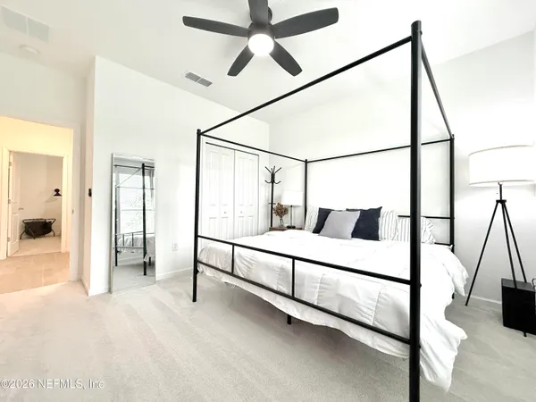 a spacious bedroom with a bed and a chandelier