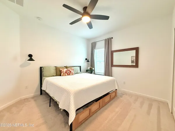 a bedroom with a bed and a ceiling fan