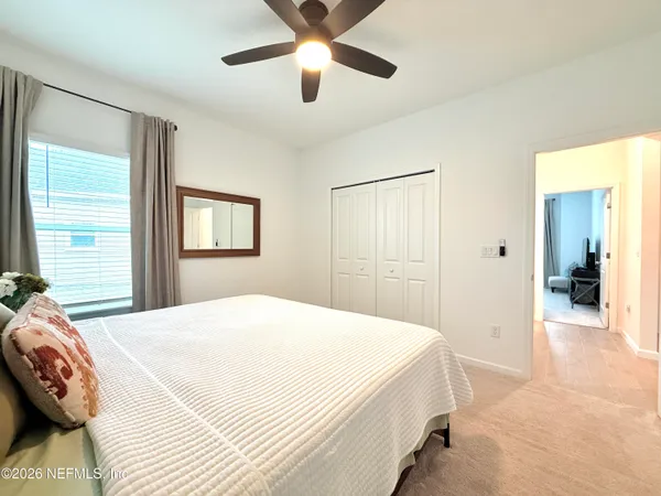 a spacious bedroom with a bed and a chandelier