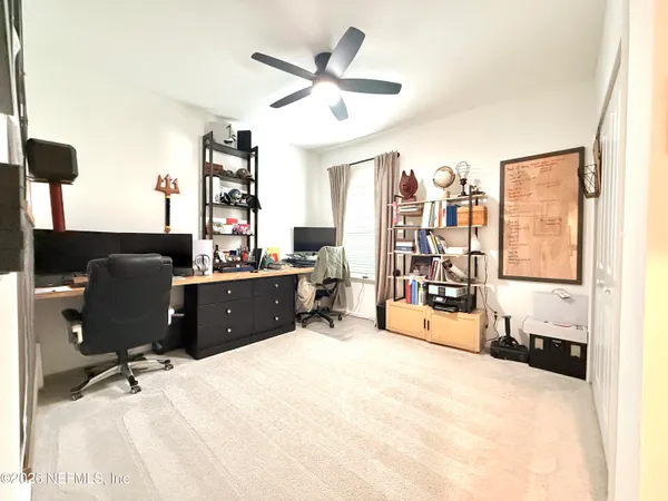 a view of a workspace with furniture and a window