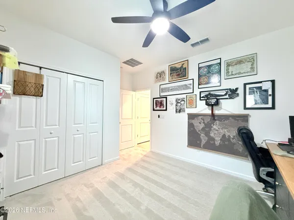 a view of a livingroom with wooden floor and a ceiling fan