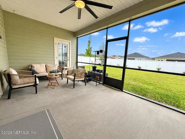a living room with furniture and a floor to ceiling window