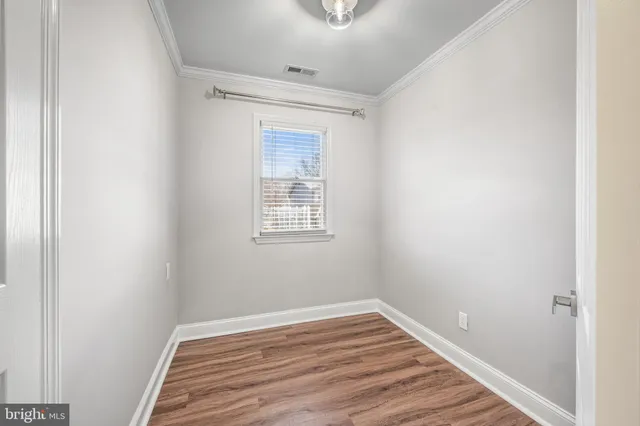 a view of a room with wooden floor and white walls
