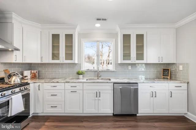 a kitchen with granite countertop white cabinets and white appliances