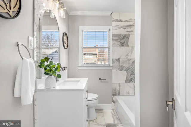 a bathroom with a granite countertop sink a toilet and a shower