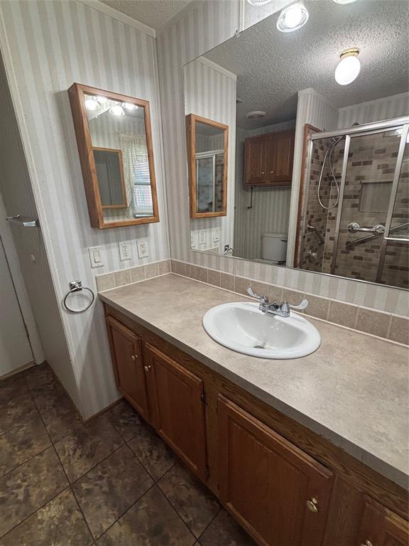 206 Holiday Rambler Drive Whitney, TX 76692 - Photo 18 of 28 Bathroom vanity with an integrated sink, laminate countertop, and wood-finish cabinetry