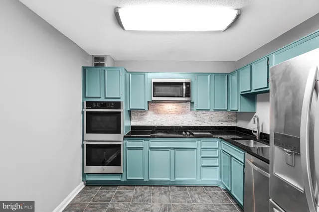 a kitchen with a sink and stainless steel appliances