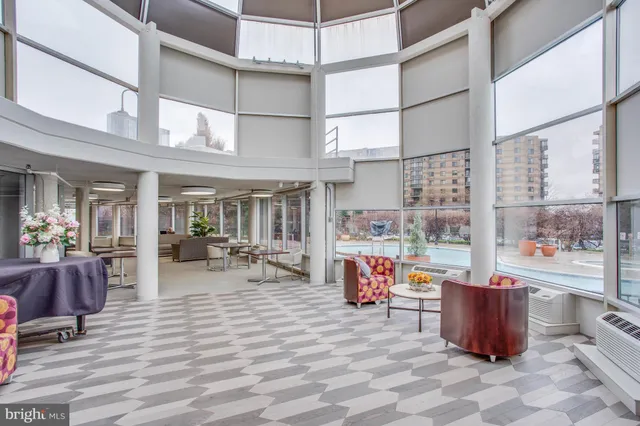 a dining room with furniture and a floor to ceiling window