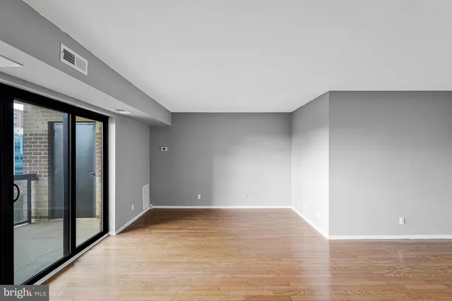 a view of an empty room with wooden floor