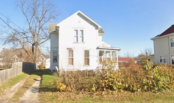 a view of a white house with a yard
