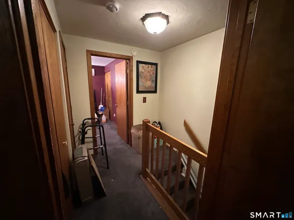 a view of a hallway with wooden floor and stairs