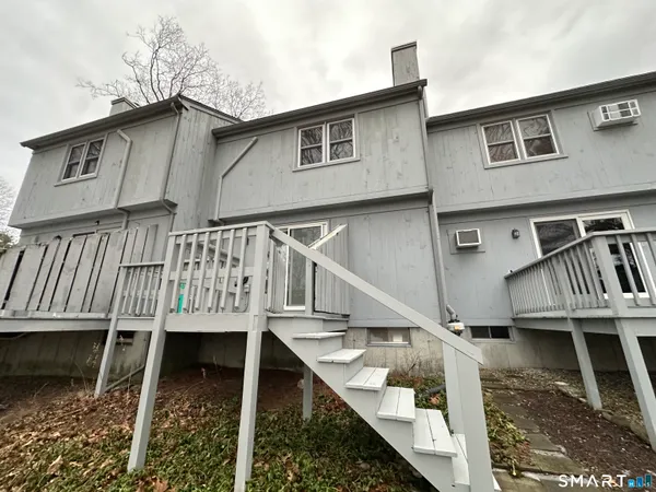 a view of a house with wooden deck front of house