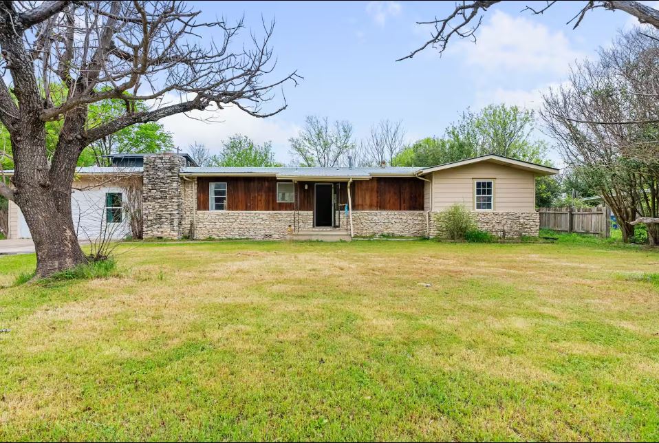 Ranch-style house featuring stone siding