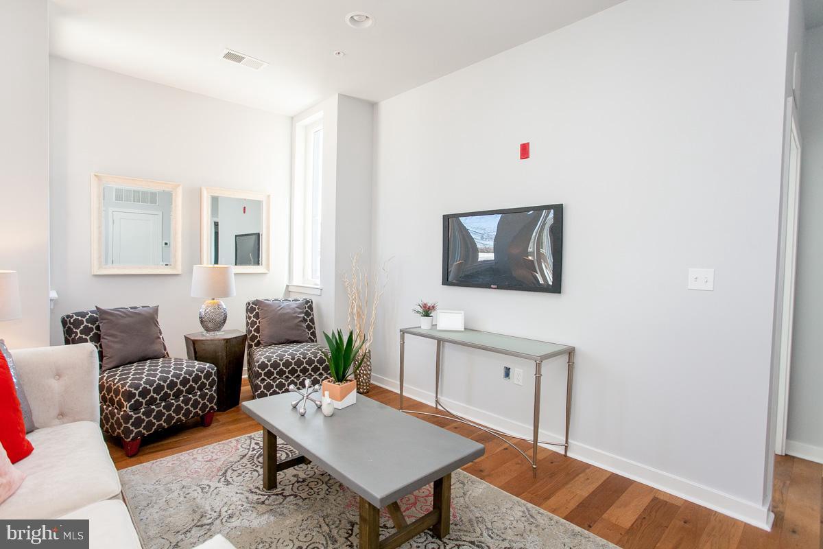 5938 Henry Avenue, Unit 1 Philadelphia, PA 19128 - Photo 7 of 19 a living room with furniture and wooden floor