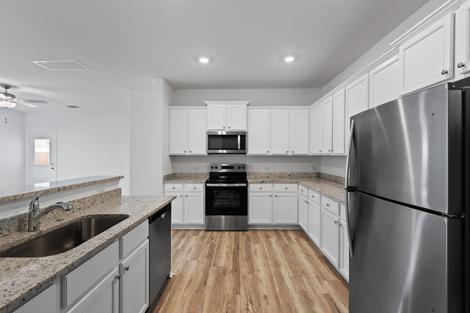 14617 Wahlbergs Way Elgin, TX 78621 - Photo 3 of 11 In the kitchen of this home, you’ll find a full suite of energy-efficient Whirlpool® appliances, including the refrigerator, spacious granite countertops, 36” upper wood cabinets with crown molding and a USB charging outlet.