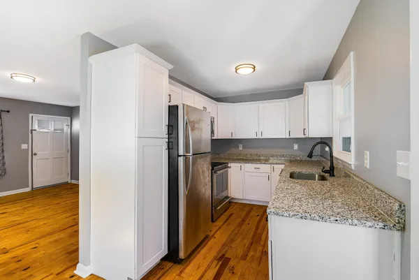 a kitchen with a refrigerator sink and cabinets