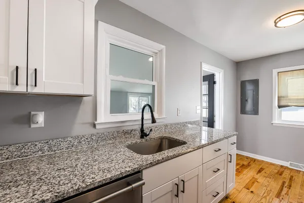 a kitchen with granite countertop a sink and cabinets