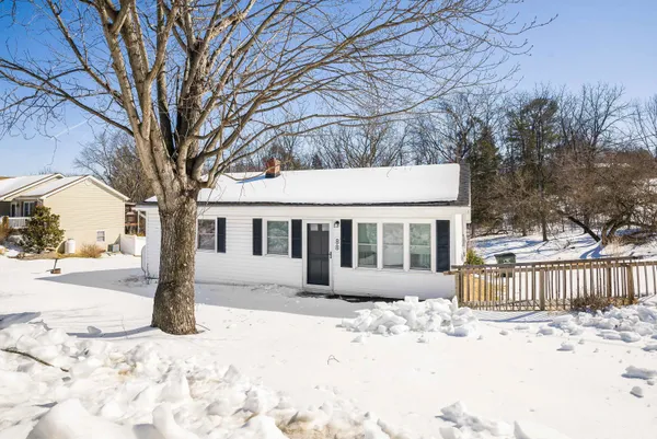 a front view of a house with a yard covered in snow