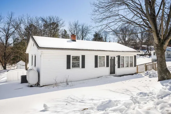 a front view of a house with a yard covered in snow