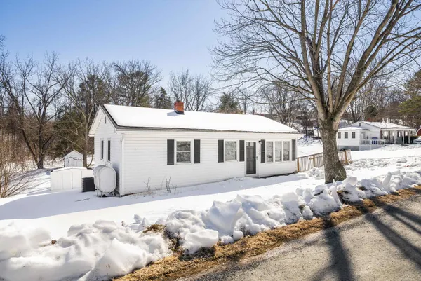 a front view of a house with a yard covered in snow