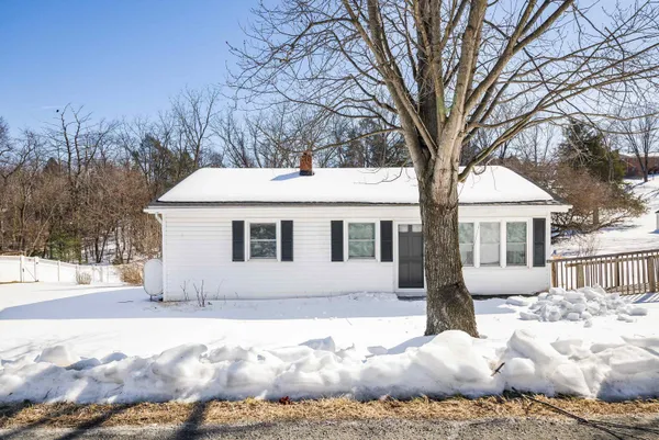 a front view of a house with a yard covered in snow