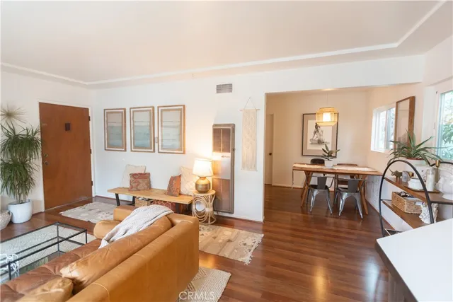 a living room with furniture a dining table and wooden floor