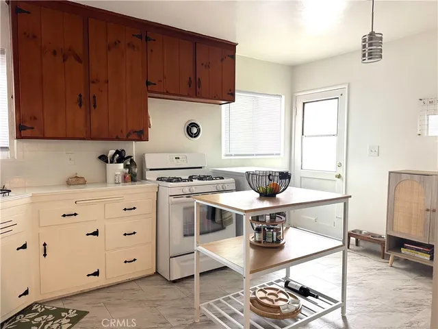 a kitchen with stainless steel appliances a stove a sink cabinets and a window