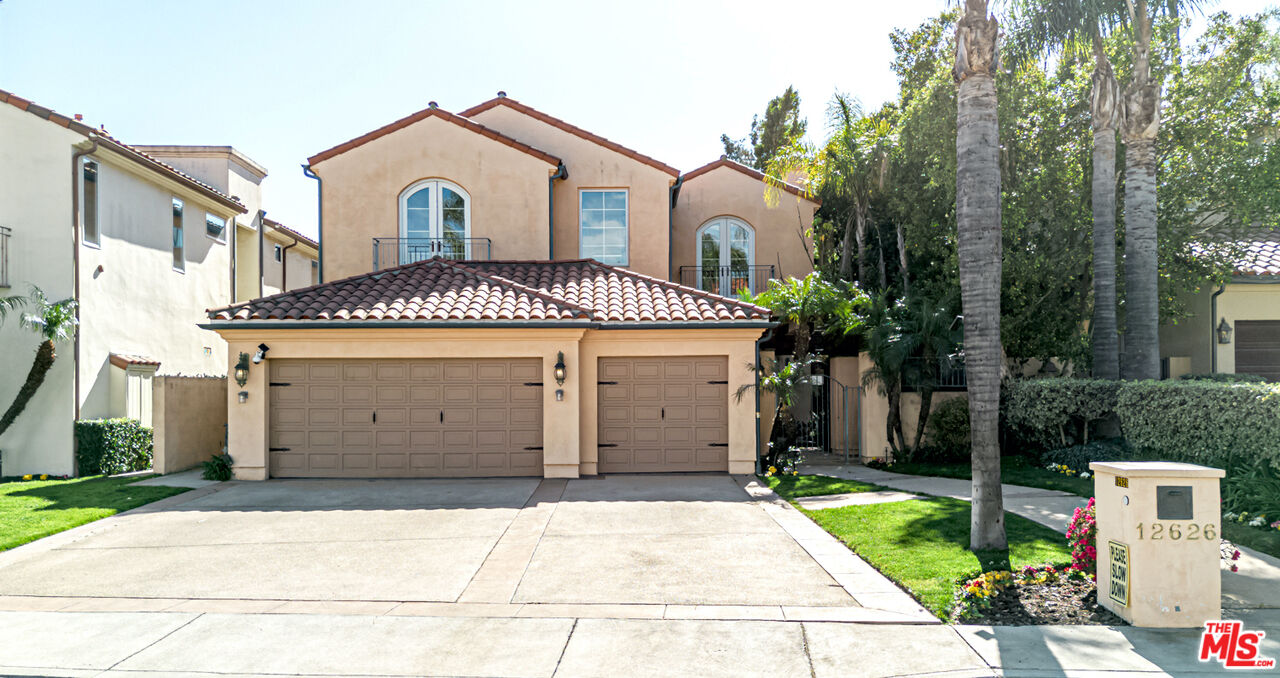 a front view of a house with a yard and trees