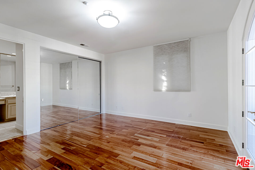 12626 Promontory Road Los Angeles, CA 90049 - Photo 14 of 34 a view of an empty room with wooden floor and a window
