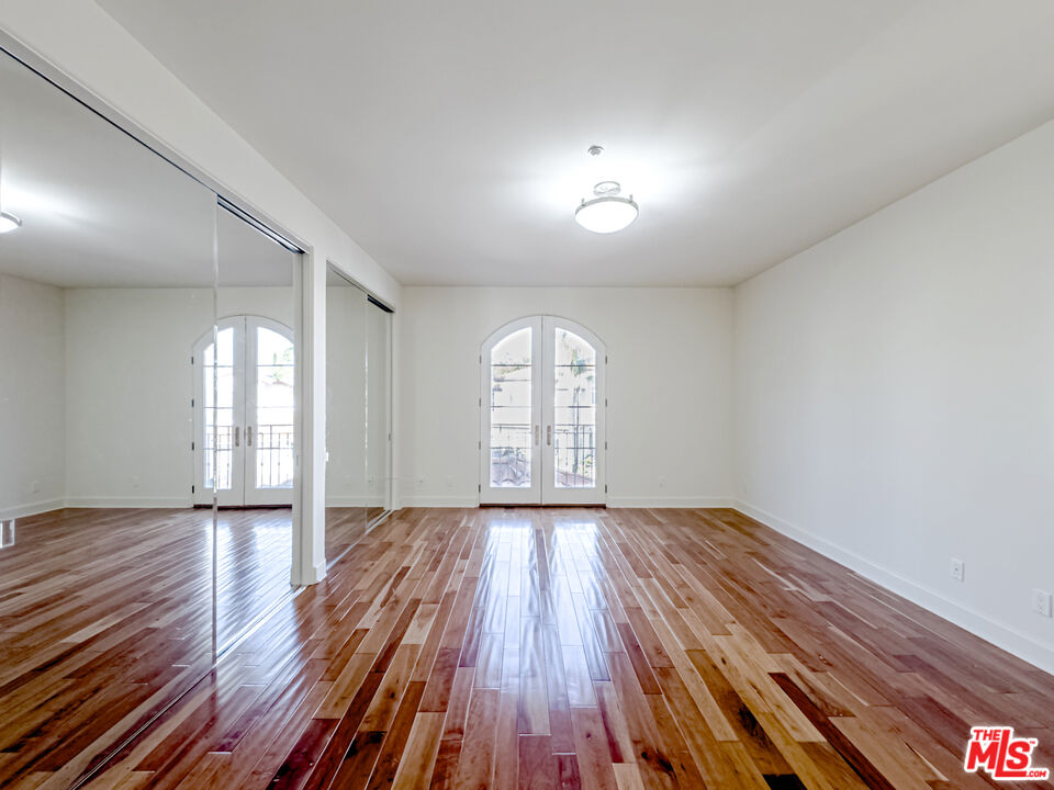 12626 Promontory Road Los Angeles, CA 90049 - Photo 17 of 34 an empty room with wooden floor and windows