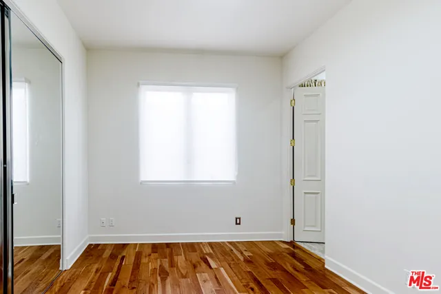a view of a room with wooden floor and a window