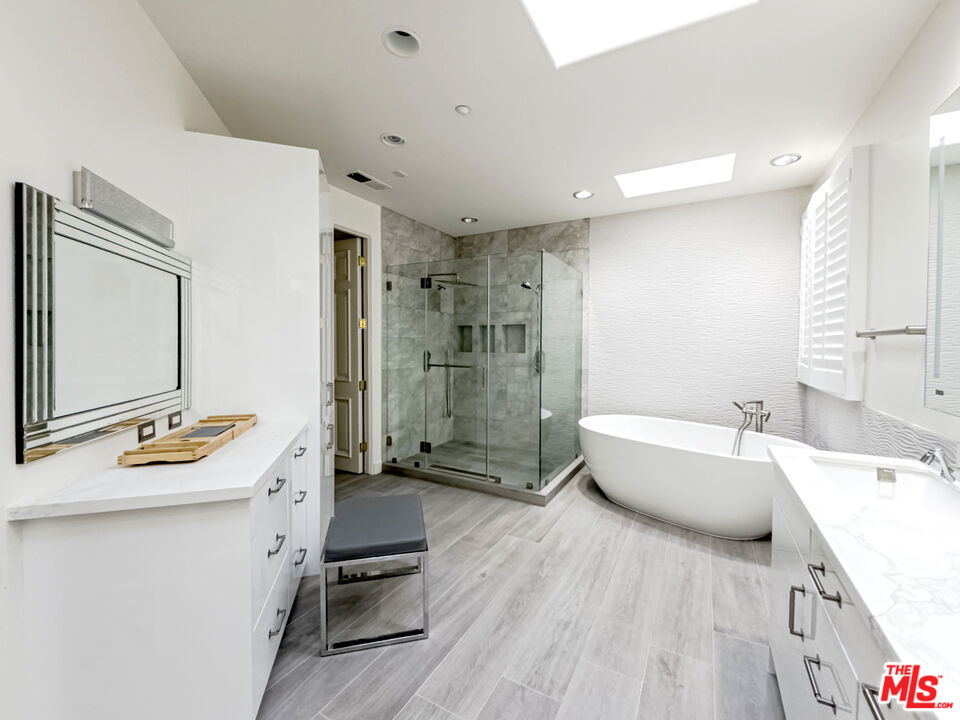 12626 Promontory Road Los Angeles, CA 90049 - Photo 21 of 34 a bathroom with a tub sink mirror and shower