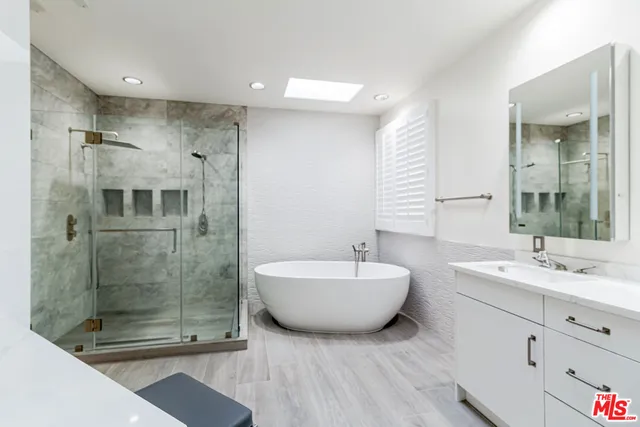 a spacious bathroom with a bathtub shower sink mirror and toilet