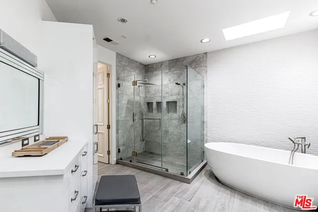a bathroom with a bathtub shower sink mirror and toilet
