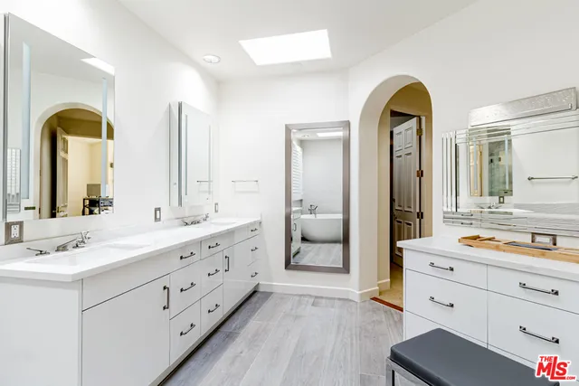 a spacious bathroom with a double vanity sink and mirror