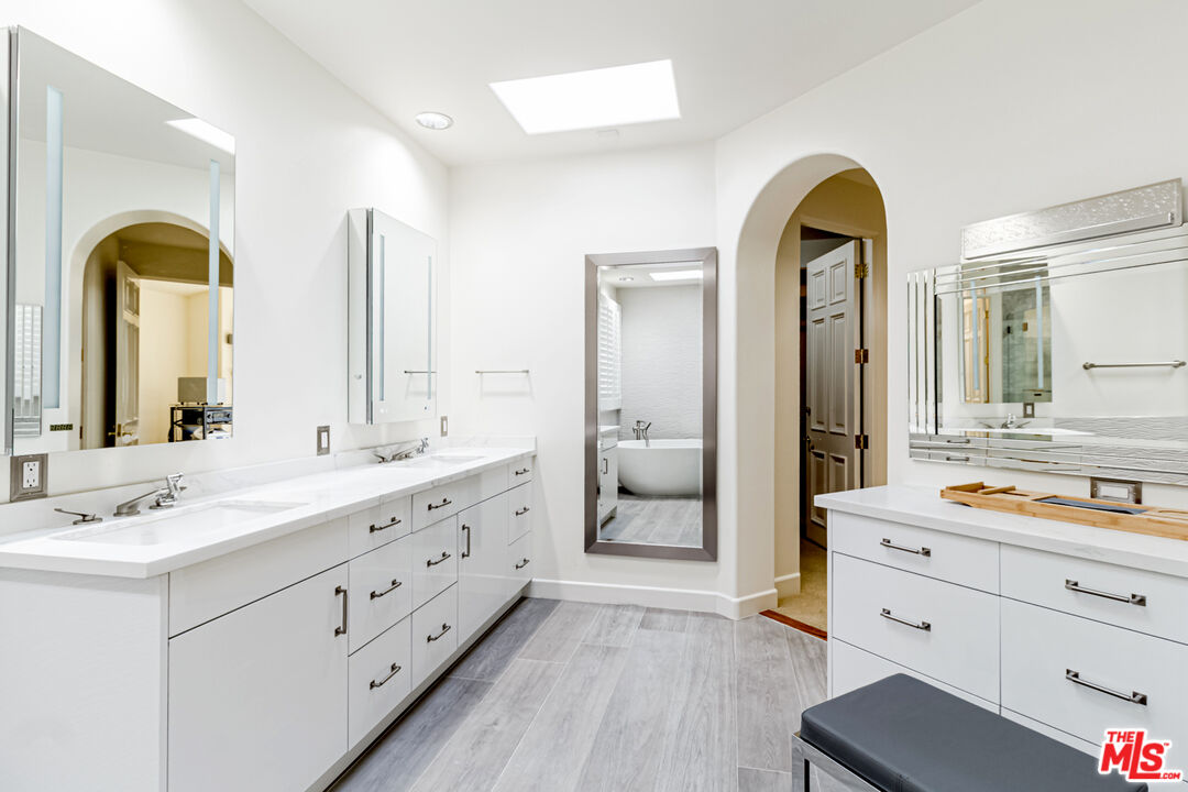 12626 Promontory Road Los Angeles, CA 90049 - Photo 24 of 34 a spacious bathroom with a double vanity sink and mirror