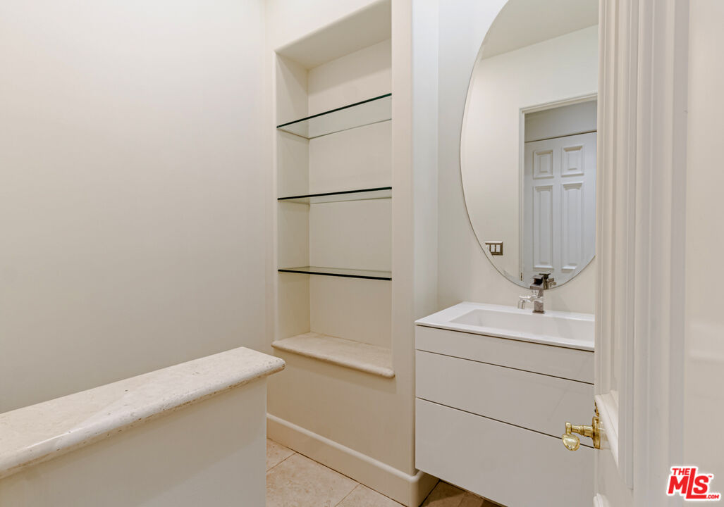 12626 Promontory Road Los Angeles, CA 90049 - Photo 28 of 34 a bathroom with a sink a toilet and a mirror